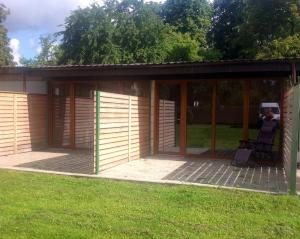 a screened in porch with a chair on a lawn at Easy Stay Apartments in Rīga