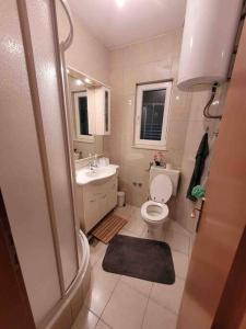 a small bathroom with a toilet and a sink at 2 bedroom apartment on the coast of the Adriatic! Watermelon Marina in Marina