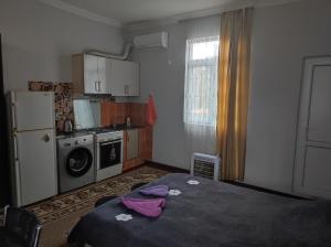 a small kitchen with a bed and a refrigerator at Guest House Koba in Batumi