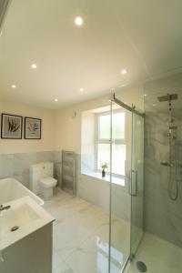 uma casa de banho com um chuveiro, um lavatório e um WC. em Foundry Farm House em Hexham