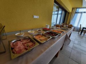 un buffet con carne y otros alimentos en una mesa en Horgász-Lak vendégház, en Nagybaracska