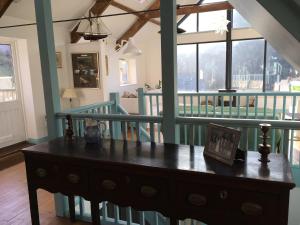 a wooden table in a room with a balcony at Lower Hillcott, Crackington Haven in Crackington Haven