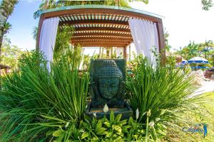 Une statue assise au milieu de quelques plantes dans l'établissement Cabanas Termas Hotel, à Gravatal