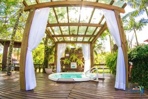 ein Pavillon mit Whirlpool auf einer Holzterrasse in der Unterkunft Cabanas Termas Hotel in Gravatal