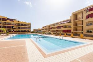 basen przed kilkoma budynkami mieszkalnymi w obiekcie OLIVIA SUNSET Perfect Stay by Sunkeyrents w mieście Puerto de Santiago
