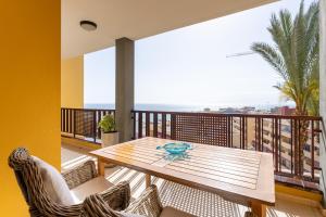 プエルト・デ・サンティアゴにある137 OLIVIA SUNSET Perfect Stay by Sunkeyrentsの木製テーブルと椅子付きのバルコニー