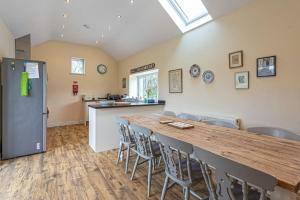 a kitchen and dining room with a long table and chairs at Gwlgri in Holyhead