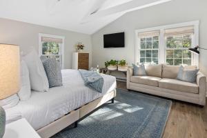 een slaapkamer met een bed en een bank bij Lambert's Cove Inn & Resort in West Tisbury