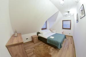 シャフラリにあるDomek w Ogrodzieのベッドルーム1室(ベッド1台付)が備わる屋根裏部屋です。