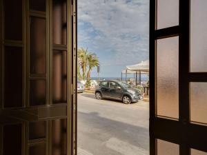 une voiture garée sur un parking avec des palmiers dans l'établissement Belvilla by OYO Marinella House, à Marinella di Selinunte