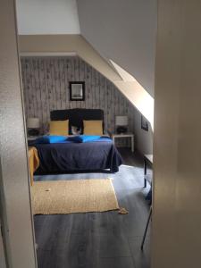 a bedroom with a bed with blue sheets and yellow pillows at Appart'hotel Maison Saint Michel in Paimpol