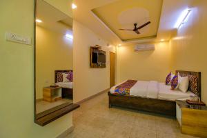 a bedroom with a bed and a ceiling fan at FabHotel Kanta Shrawan Arcade in Bhopal