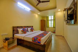 a bedroom with a large bed with a ceiling fan at FabHotel Kanta Shrawan Arcade in Bhopal