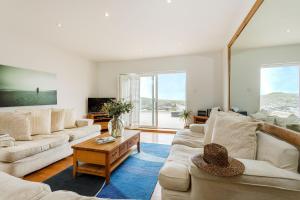 Surfside, Porth, North Cornwall في نيوكواي: غرفة معيشة مع كنبتين وطاولة