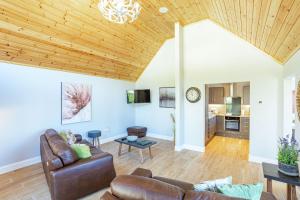 a living room with a wooden ceiling at Kestrel Lodge 6 with Hot Tub in Newton Stewart