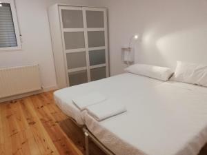 Cama blanca en habitación con ventana en Calle Carmen Céntrico Amplio, en Pamplona