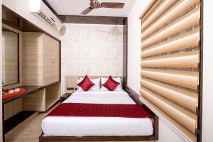 ein Schlafzimmer mit einem großen Bett mit roten Kissen in der Unterkunft FabHotel The Leela Park in Bangalore