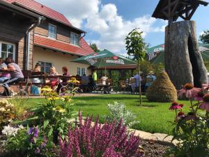 eine Gruppe von Menschen, die an Tischen im Garten sitzen in der Unterkunft Gasthaus Bukoitza in Radensdorf