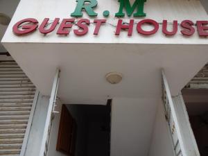 a sign for a guest house on top of a building at R M Guest House in Kālapettai