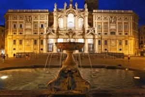 ローマにあるCasa Tua a Montiの夜の大きな建物前の噴水