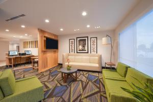 uma sala de estar com cadeiras verdes e um sofá em Holiday Inn Express Donaldsonville, an IHG Hotel em Donaldsonville