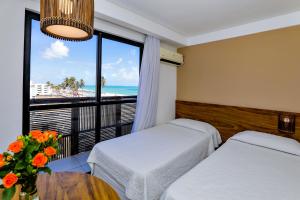 Cama ou camas em um quarto em Porto Suítes Natal Hotel