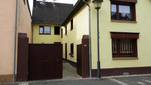 a yellow house with a gate and a street light at Apartement Victoria in Swisttal