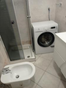 uma casa de banho com uma máquina de lavar roupa e uma máquina de lavar e secar roupa em exclusive house sardinia em Cala Gonone