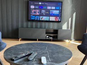a living room with two remote controls and a tv at Apartament Ogrodowa Deluxe in Warsaw