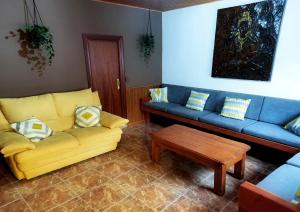 Sala de estar con 2 sofás y mesa de centro en Casa Rural Burón, en Posada de Valdeón