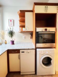 a kitchen with a washer and dryer in it at Vándor Apartman in Veszprém