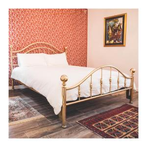 - une chambre avec un lit doté d'un cadre doré dans l'établissement Apartmaji Aucin - Brda, à Kojsko