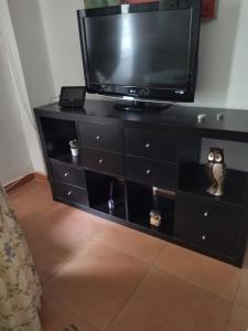 a black dresser with a television on top of it at Santa Justa in Seville