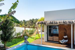 a house with a hammock next to a swimming pool at Akivillas Setúbal Paradise in Setúbal