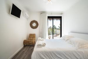 a white bedroom with a bed and a window at Akivillas Setúbal Paradise in Setúbal +46 photos