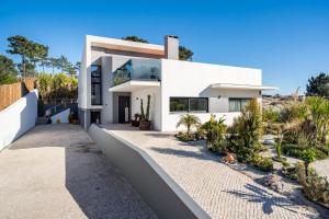 a white house on the hill with plants at Akivillas Setúbal Paradise in Setúbal