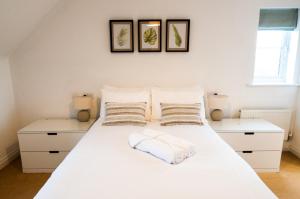 a bedroom with a white bed with two pillows at Newly Furnished Aztec House (6 separate beds) in Derby