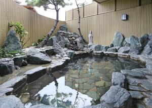 Awaji International Hotel The Sunplaza في Sumoto: بركة في حديقة فيها صخور