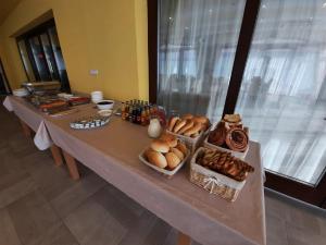 una mesa larga con pan y pasteles. en Vándor Vendégház, en Baja