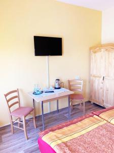 Zimmer mit einem Tisch mit Stühlen und einem TV in der Unterkunft Spreewaldhof in Vetschau