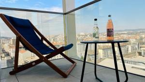 niebieskim krzesłem i stołem z butelką w obiekcie Studio BEL MOD Mont d'Or - Belvédère Moderne w mieście Lyon