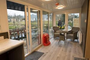 a screened in porch with a table and chairs at Walsh's - Mill Lodges-Cabins in Maghera