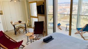 a bedroom with a bed and a view of a city at Studio BEL MOD Mont d'Or - Belvédère Moderne in Lyon