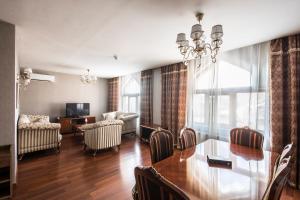 a dining room with a table and a living room at Sheki Palace Hotel in Sheki