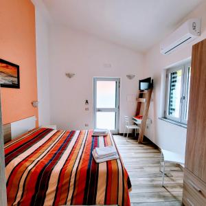 a bedroom with a bed with a colorful striped blanket at B&B da AnnaMaria in Maratea