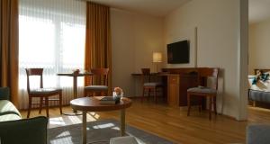 a hotel room with a bed and a living room at NewLivingHome Residenzhotel Hamburg in Hamburg