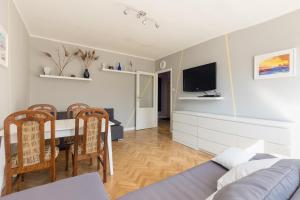 un soggiorno con tavolo da pranzo e TV di Krasiński Garden 2-bedroom Apartament a Varsavia