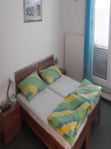 a bedroom with a bed with yellow and blue pillows at Apartments Da - Dent in Sveti Ivan Zelina