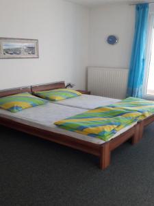 ein Schlafzimmer mit einem großen Bett mit einem Holzrahmen in der Unterkunft Apartments Da - Dent in Sveti Ivan Zelina