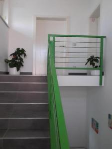 a stairway with a green railing and some stairs at Apartments Da - Dent in Sveti Ivan Zelina